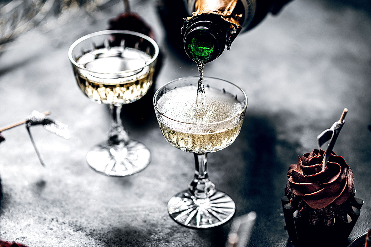 Champagner wird in zwei nostalgisch aussehende Champagner-Schalen eingeschenkt