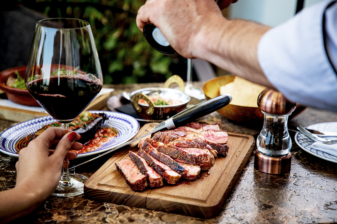 Wein zu Steak gereicht auf einem rustikalen Tisch