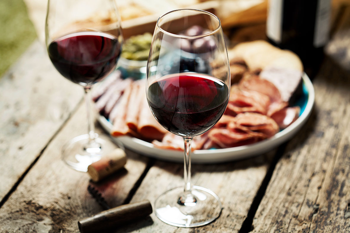 Wein zu Antipasti auf einem Teller auf einem Holztisch